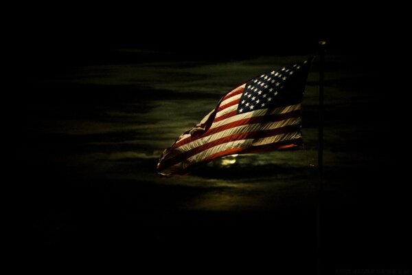 American flag illuminated by a full moon