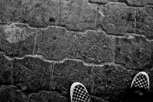 Feet in sneakers on a stone wall