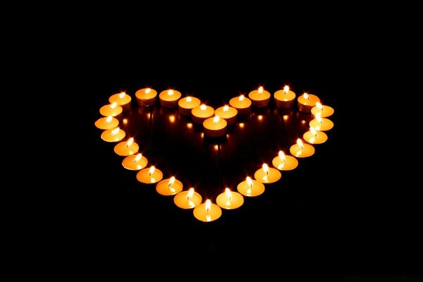 Romantic heart made of candles in the dark