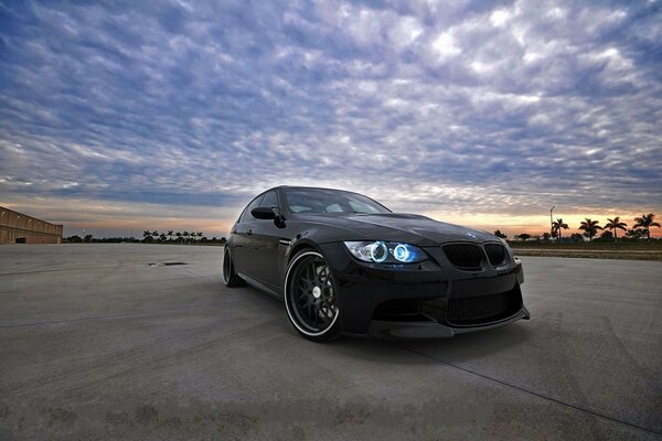 Black car on the road under a blue sky