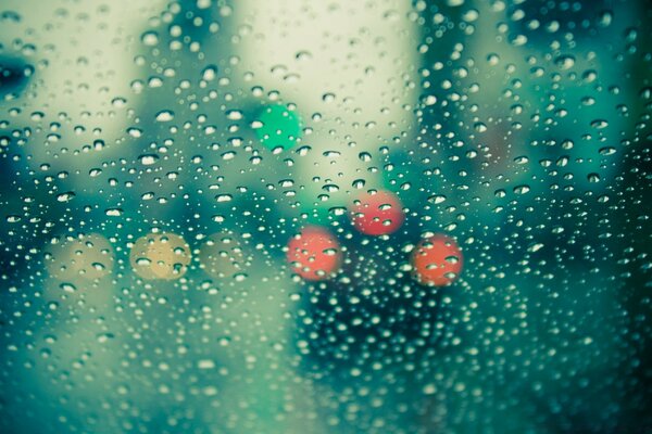 Multicolored lights through glass in raindrops