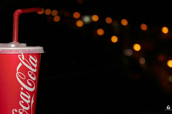 A bright red cup with a drink on a dark background with highlights