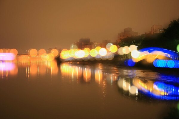 Blurred glare of multicolored lights on the embankment