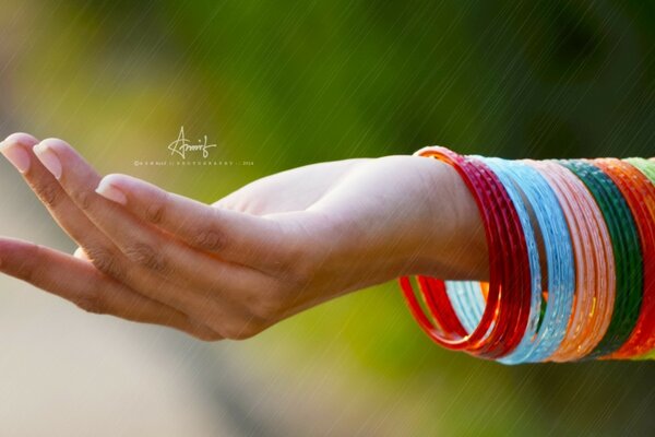 Mano de mujer con pulseras y letras multicolores