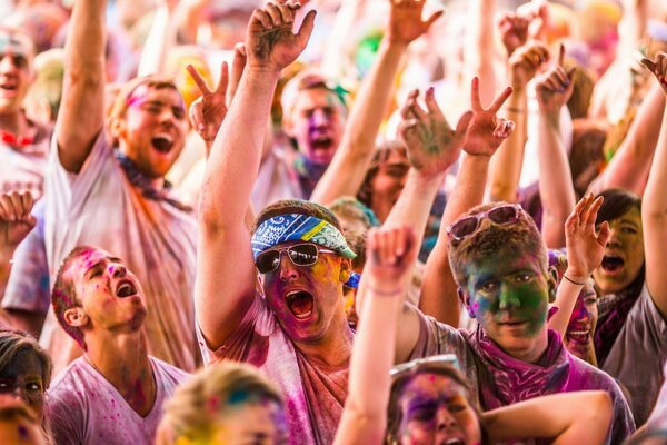 A large group of men smeared with paint and raised hands