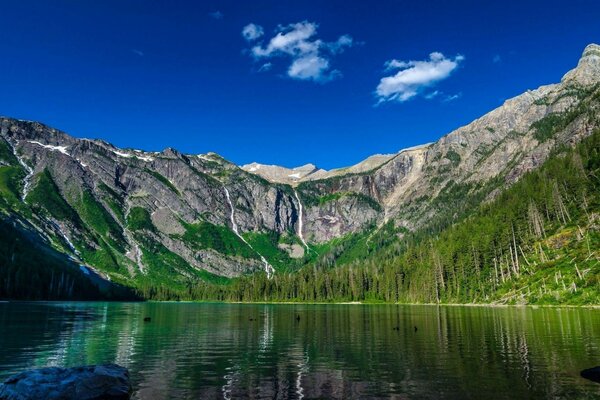 A lake surrounded by mountain hills and forest