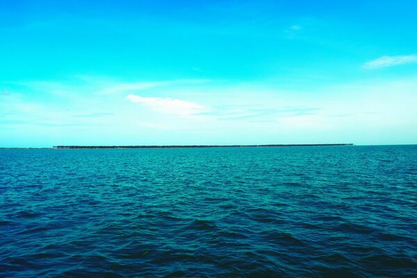 Oceano blu su uno sfondo di cielo blu