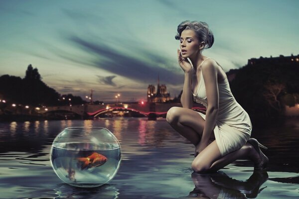 A girl with an aquarium on the background of a beautiful landscape