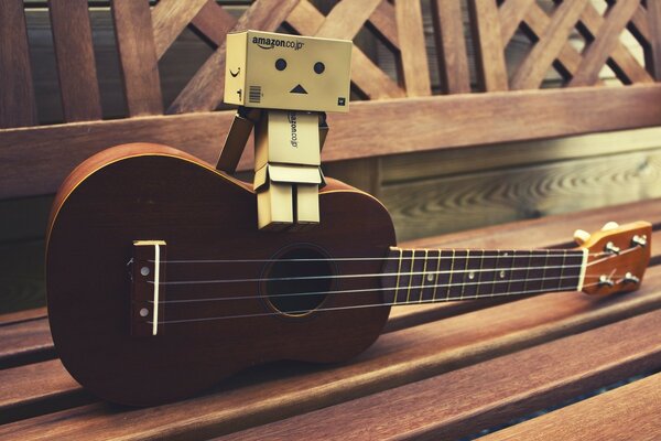 Four-string guitar on a wooden bench