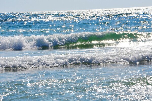 A sea wave in the rays of the sun