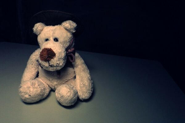 An old teddy bear toy on a dark background