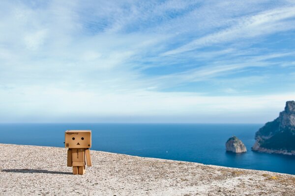 Cardboard man on the background of the ocean