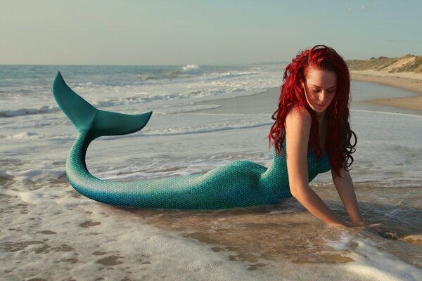 Ragazza sirena in riva al mare