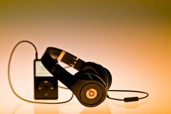 Player and large headphones on an orange background