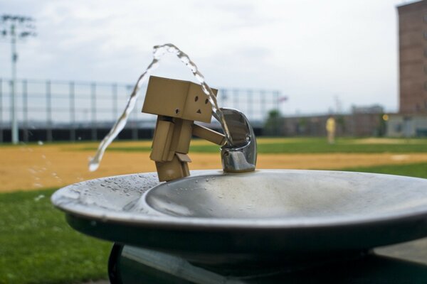 Creative photo of a cardboard man near a water fountain