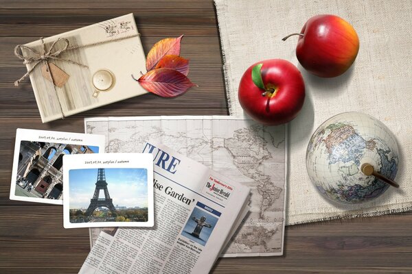 Pommes, carte postale et journal sur la table