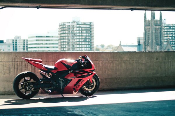 Moto deportiva roja en el fondo de la ciudad