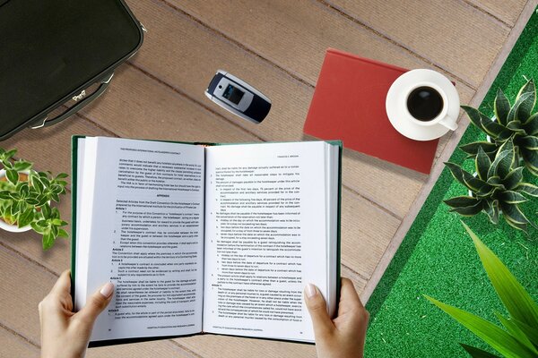 Photo à la première personne d une jeune fille lisant un livre sur le bureau avec une tasse de café