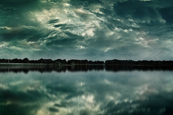 Reflet de la forêt dans un lac profond au crépuscule