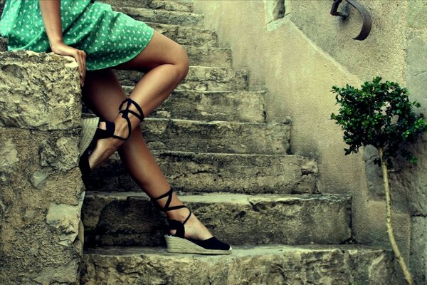 Jambes féminines sur un escalier en pierre