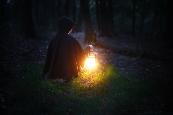 Uomo con lanterna di notte nella foresta