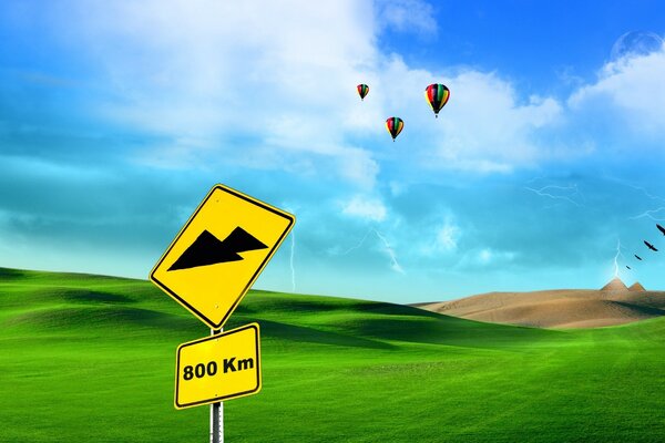 Three balloons on a background of green grass and blue sky