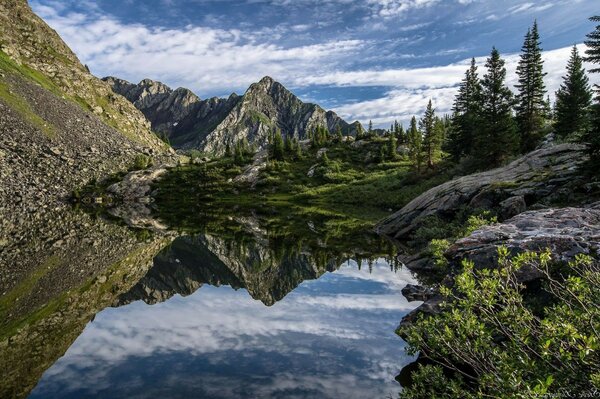 O céu reflete-se na água nas montanhas