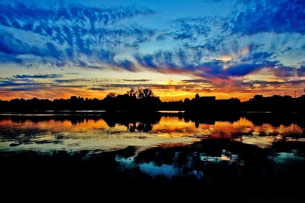 Ein düsterer Sonnenuntergang spiegelt sich im Wasser wider