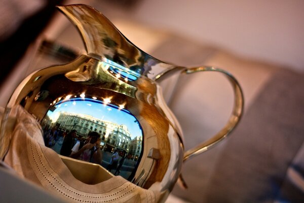 Golden jug with reflection on the background