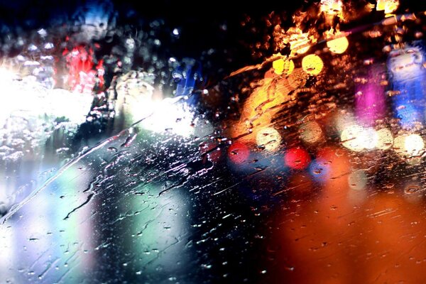 Las gotas de lluvia en el parabrisas son como un arco iris