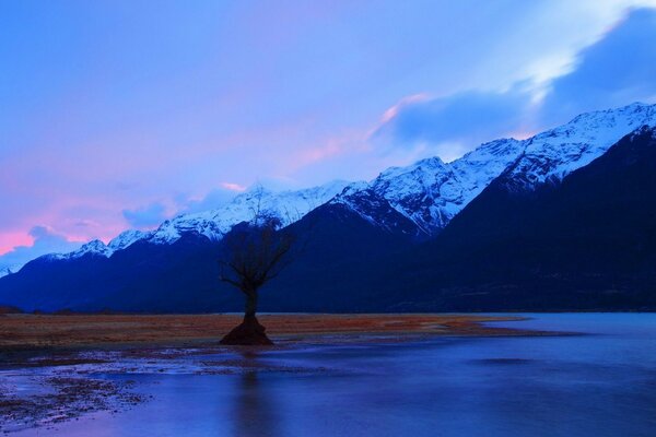 Sonnenuntergang auf den Gipfeln der Berge und ein herrlicher Fluss