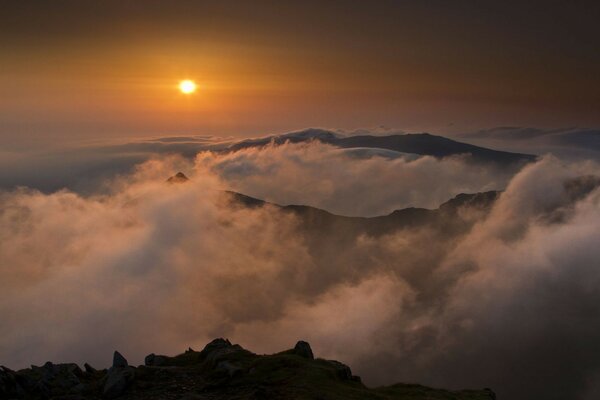 Puesta de sol en las montañas con niebla