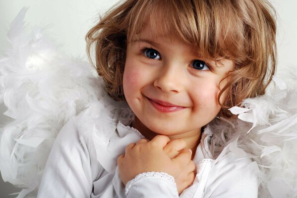 A cute child in white clothes folded his arms on his chest