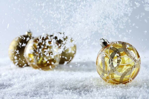 Goldene Weihnachtskugeln im Schnee