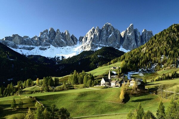 Piede di montagna rocce alberi erba villaggio strade neve