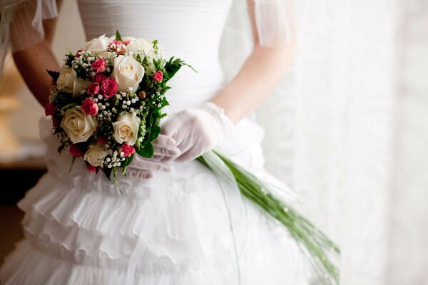 Hochzeitskleid für die Braut und ein Strauß weißer Rosen