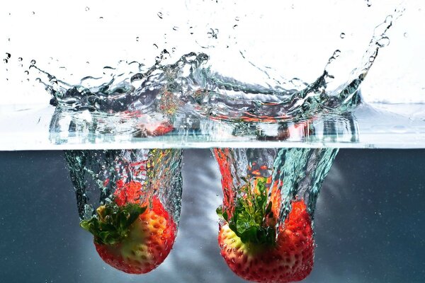 Falling with a splash of strawberries into the water