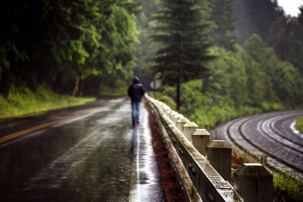 一个男人在潮湿的道路中间