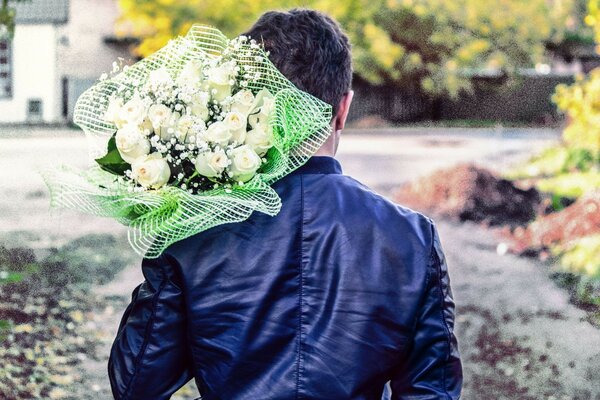 The guy is carrying a bouquet of white roses