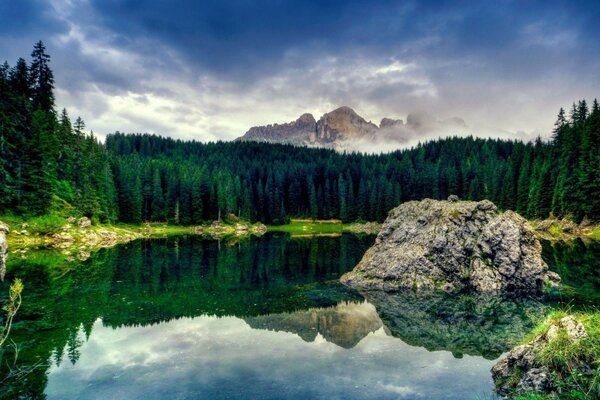 Lac de Taïga avec une belle réflexion et une pierre au centre