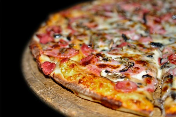 A slice of pizza in close-up on a black background