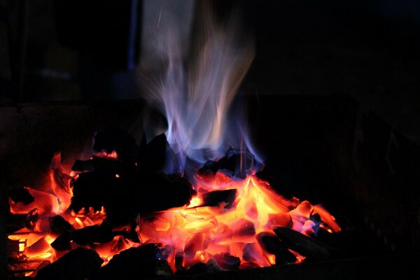 A bonfire with a blue flame on a black background