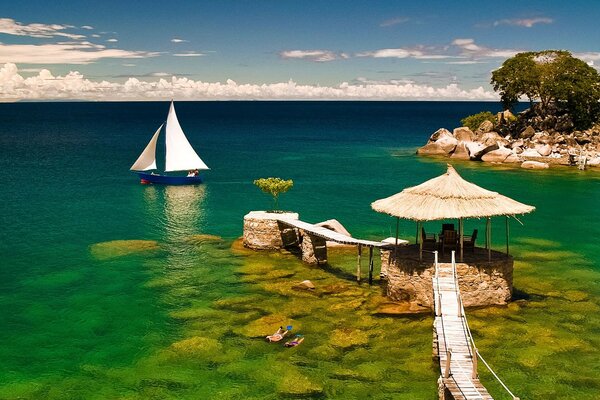 Velero de madera e islas de piedra entre aguas turquesas