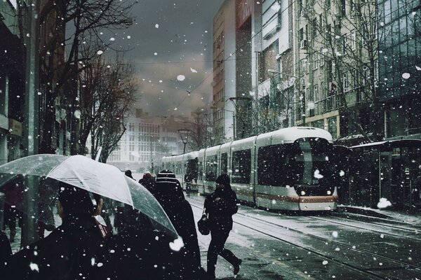 Tram e ragazza sotto la neve improvvisa in città