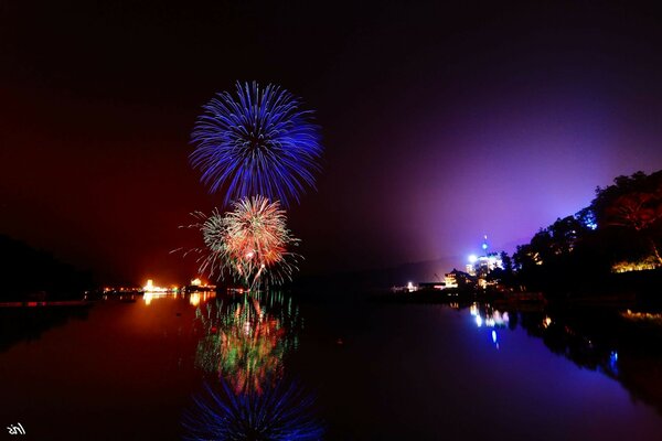 Fireworks in the city at night near the pond