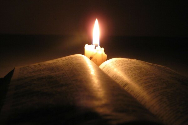 An open book over a lit candle