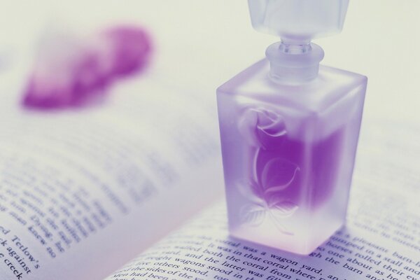 Flacon de parfum violet sur le livre ouvert