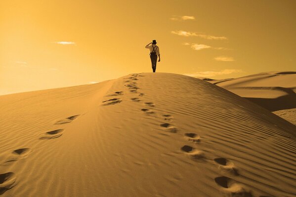 Uomo che cammina sulle dune di sabbia