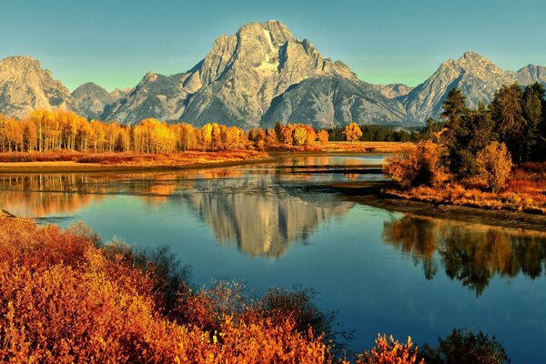 Reflejo de las montañas en el río de otoño