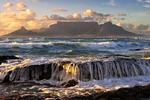 Marea dell oceano al tramonto sullo sfondo della montagna